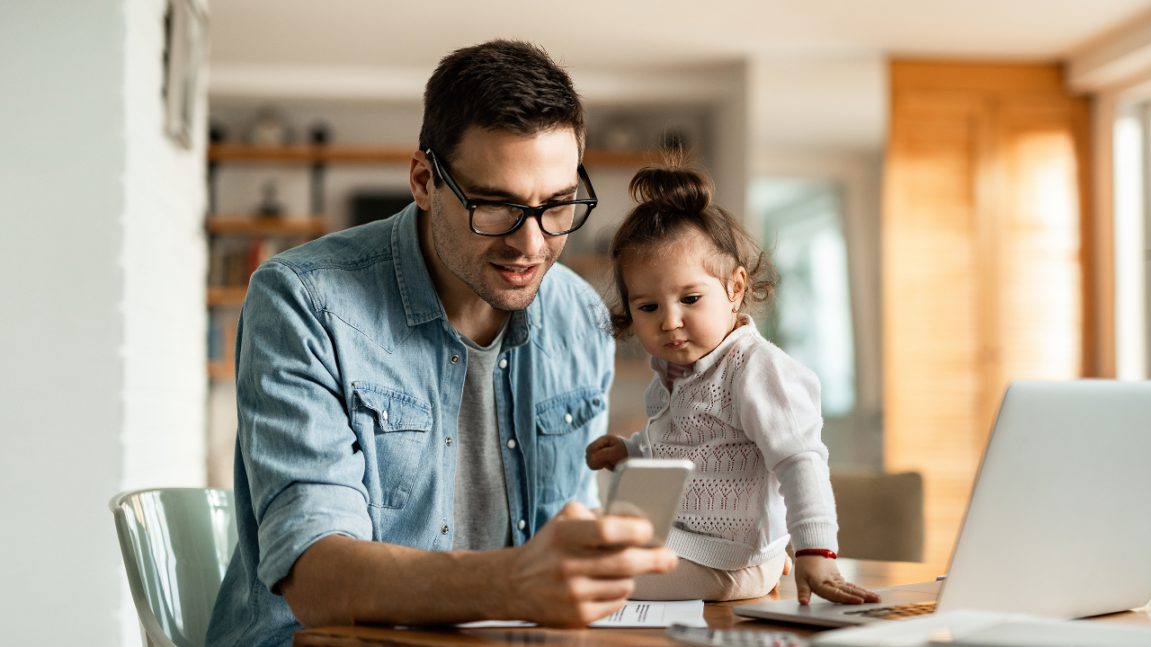 A man together with his little girl looking and his mobile phone; image used for HSBC LK mobile banking page.