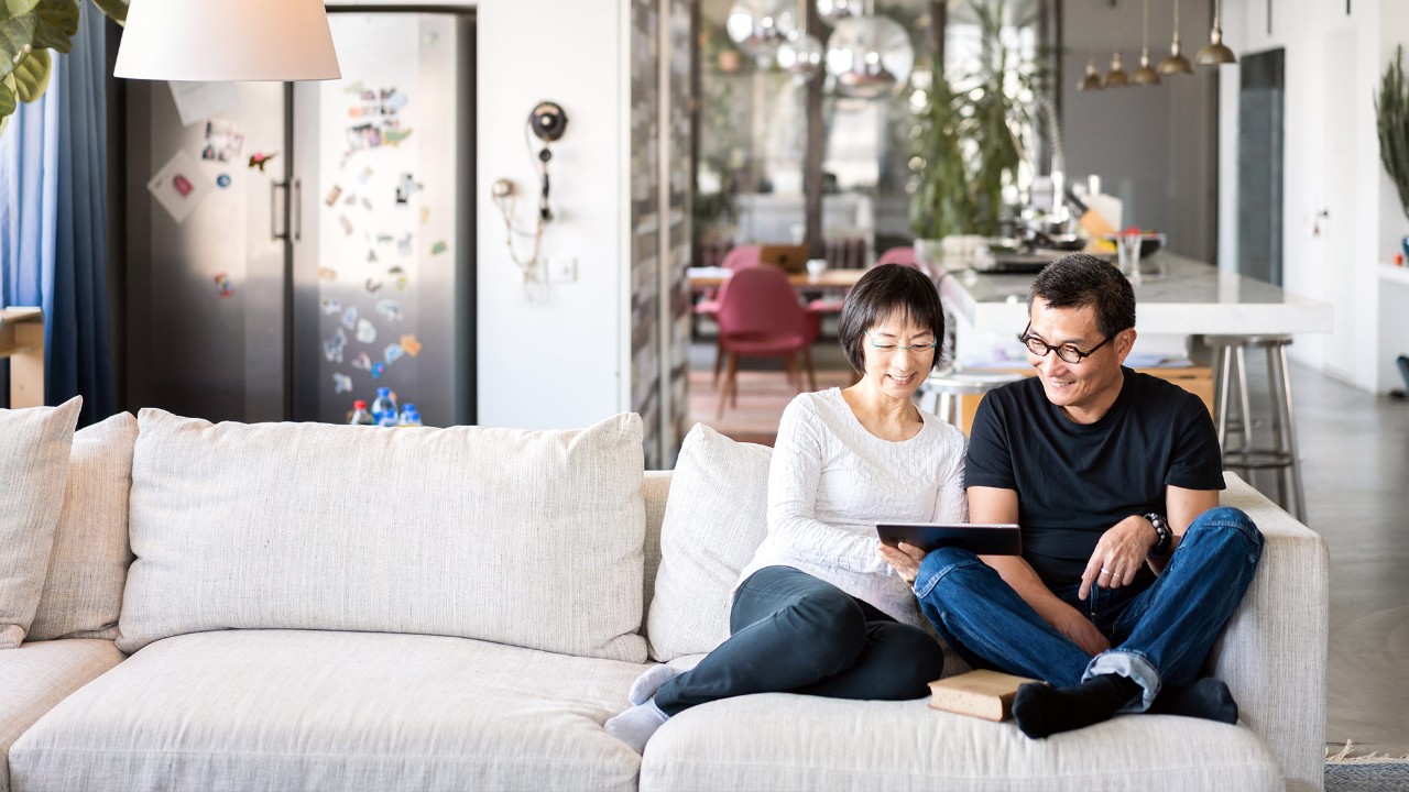 A couple is using tablet in the living room; image used for "save for the future" article.