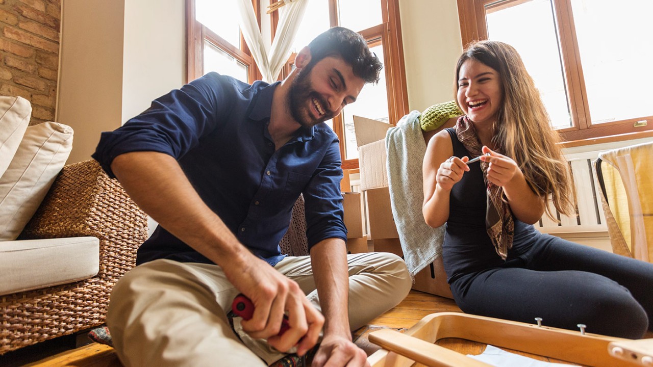 a couple assembling furniture together happily; image used for HSBC LK Advance Preferential rates on borrowing page.