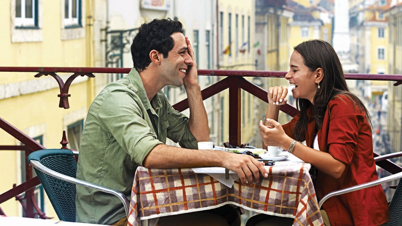 a young couple chatting happily in a cafe's balcony seats; image used for HSBC LK Preferential rates and rewards page