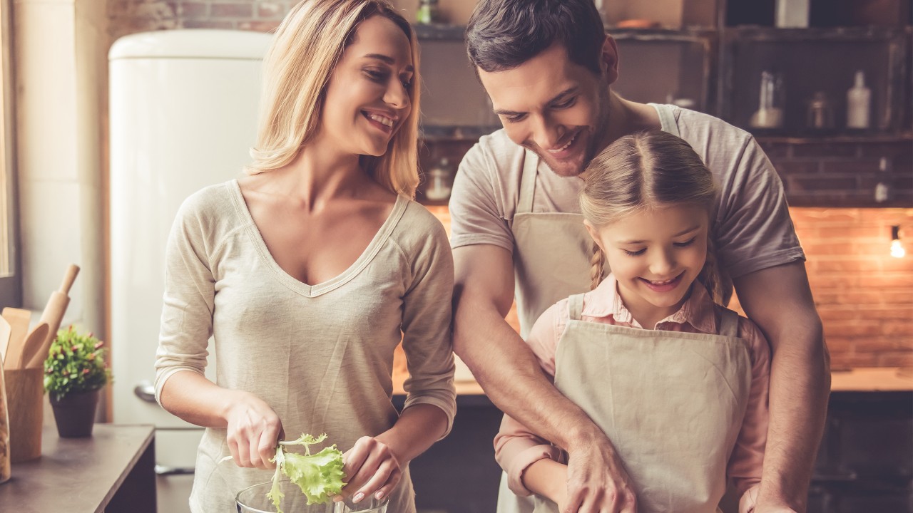 a happy family of three cooking together; image used for HSBC Sri Lanka Credit Cards Rewards