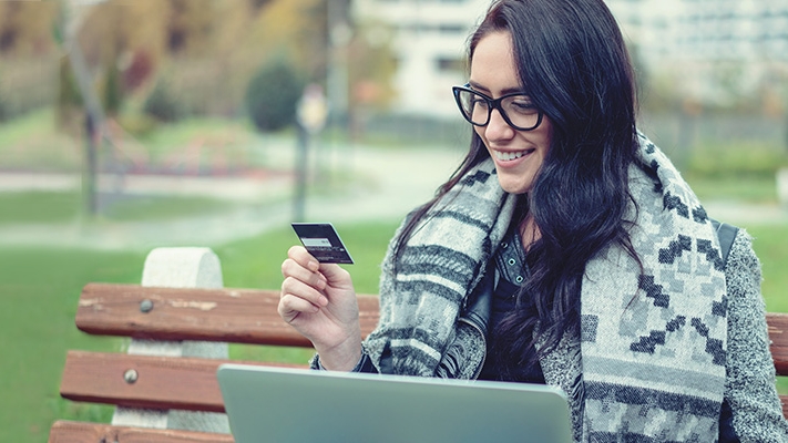 a woman is using credit card with her laptop; image used for HSBC Sri Lanka Online Banking landing page