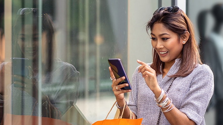 a woman is using mobile to check text message; image used for HSBC Sri Lanka ways to bank text alert