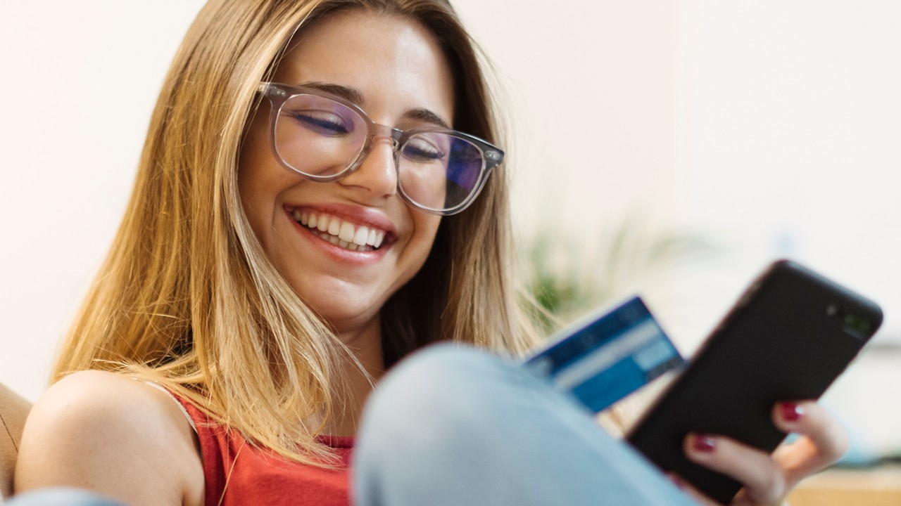 a woman is using credit card with her mobile; image used for HSBC Sri Lanka Mobile Banking landing page