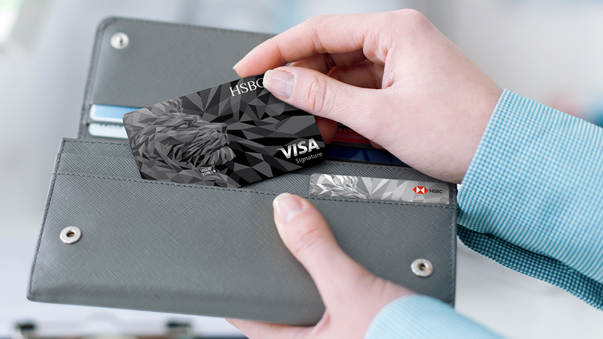 An HSBC credit card is taken out from a wallet; image used for HSBC LK Advance credit card application page.