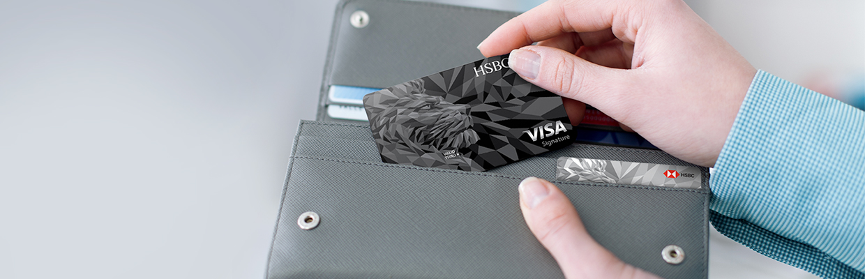 An HSBC credit card is taken out from a wallet; image used for HSBC LK Advance credit card application page.