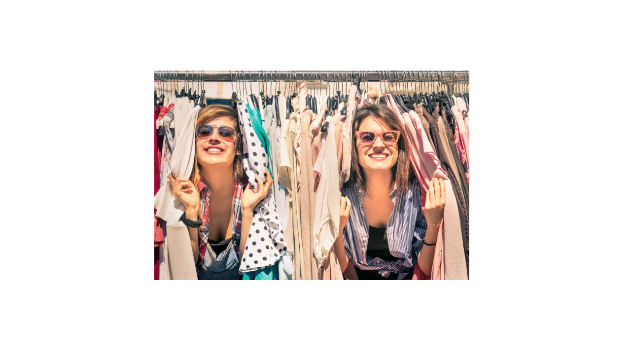 two girls coming out from a bunch of clothes