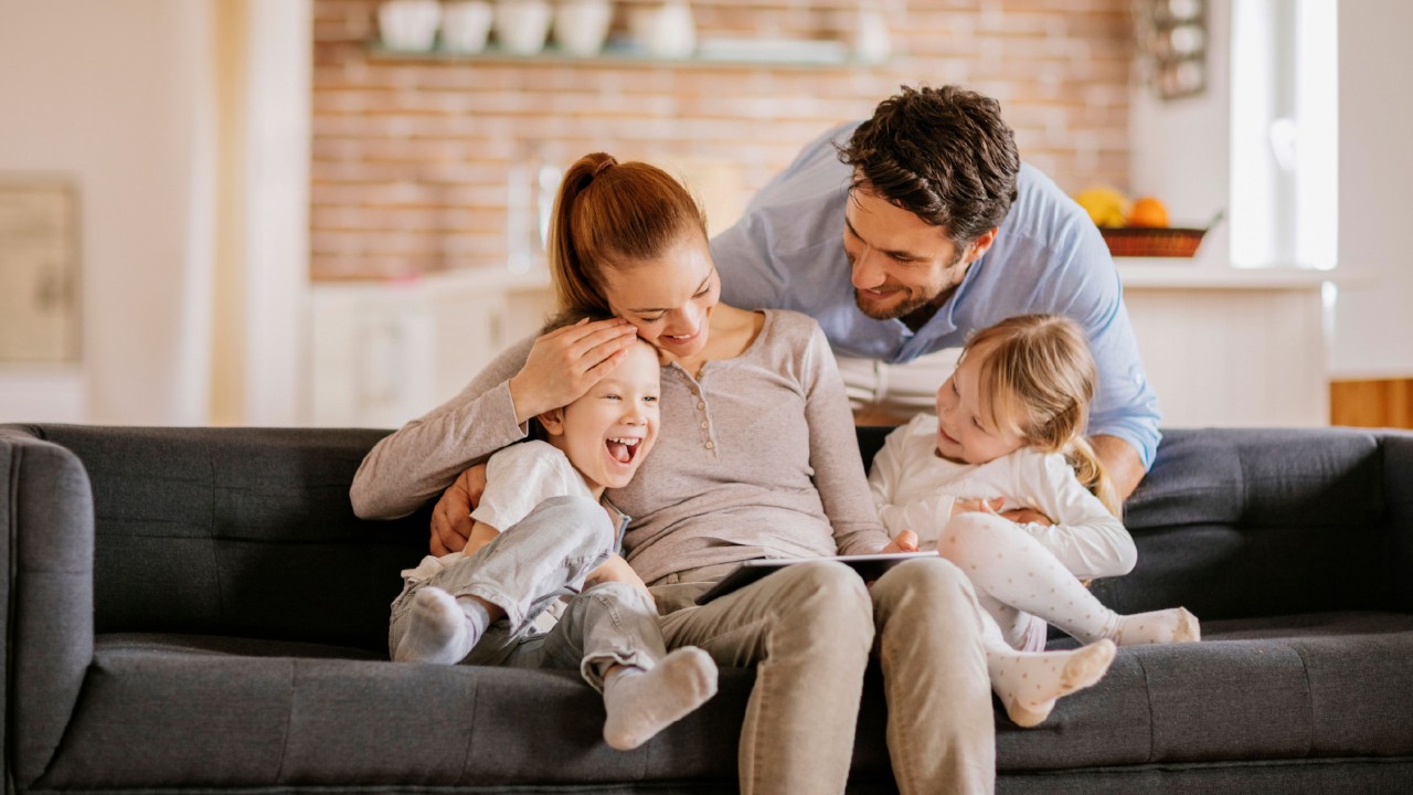 A family is in living room and smiling