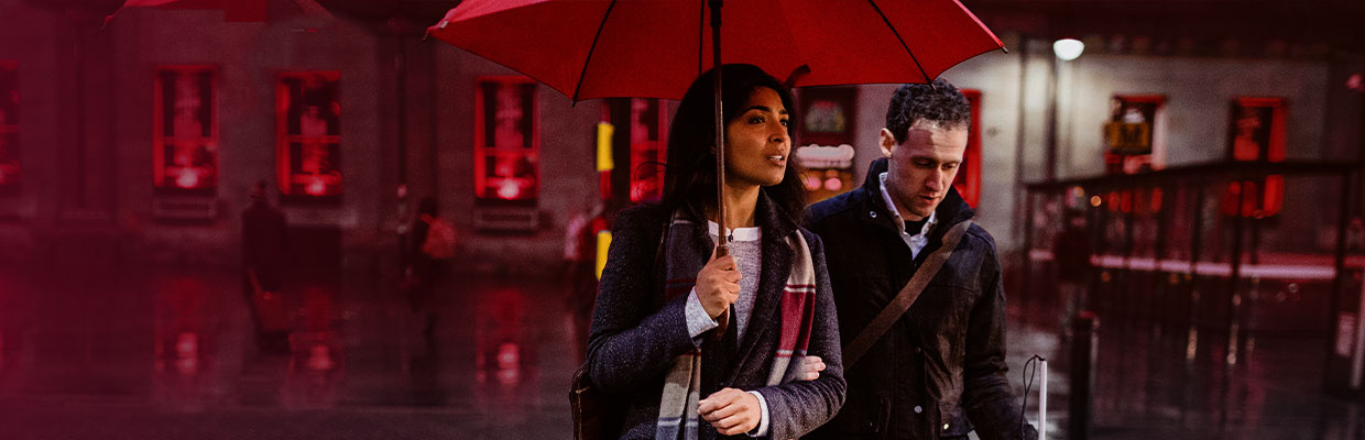 couple with umbrella walking at night; image used for HSBC Sri Lanka global insurance page.