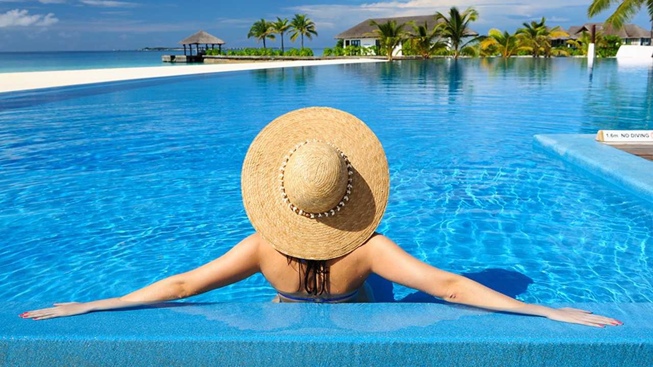 Woman with hat in swimming pool; image used for HSBC Sri Lanka Premier Offers Travel and Leisure offers page